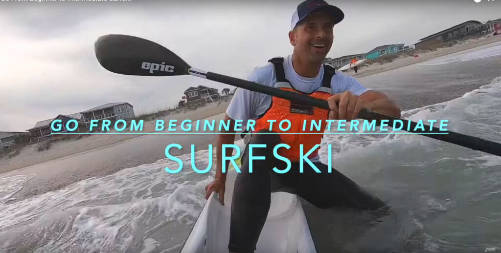 Surfski paddler laughing as he steps into surf - Go from beginner to intermediate surfski